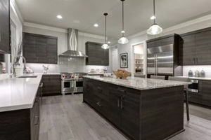 modern gray kitchen features dark gray flat front cabinets paired with white quartz countertops and a glossy gray linear tile backsplash