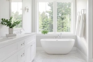 bright and modern white bathroom with freestanding tub and large window overlooking greenery