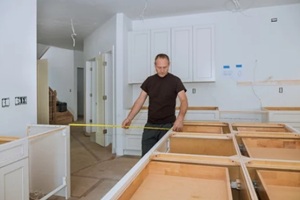 man using tape measure for measuring on kitchen in for home improvement
