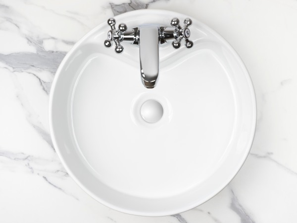 Round bathroom washing sink on marble stone surface, top view