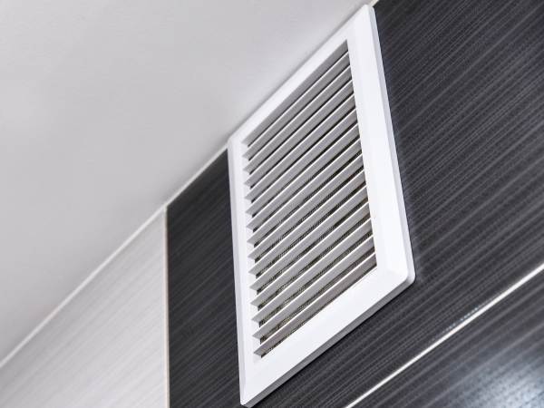 Grid of the ventilation system on the wall in bathroom in the house