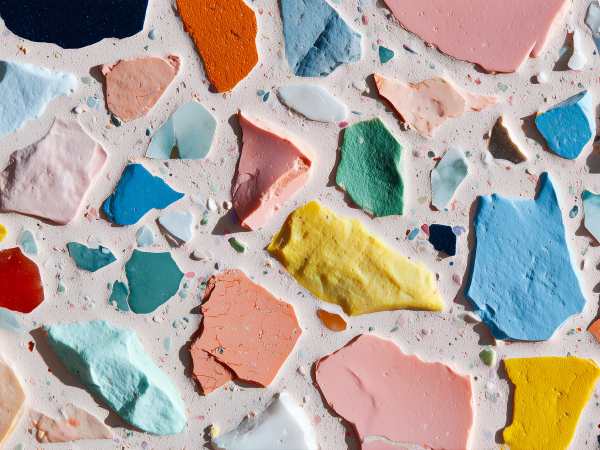 Colorful sea glass pieces scattered on a terrazzo surface.