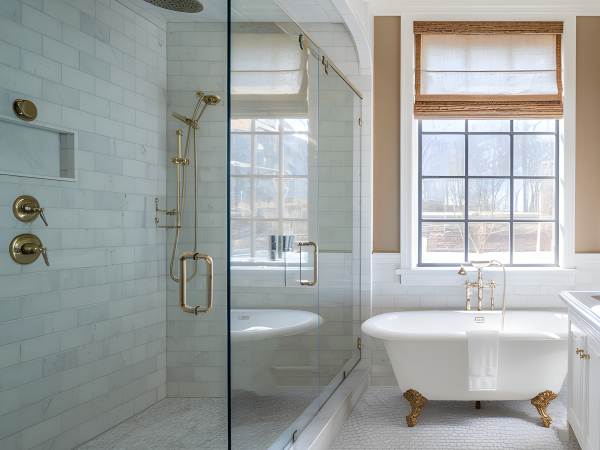 Upscale bathroom with a frameless glass shower, a marble countertop, and luxury fixtures.