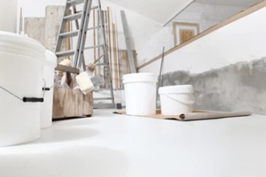 low angle of indoor shot of construction or building site of home renovation with tools on white floor with paint buckets and primer jerry can