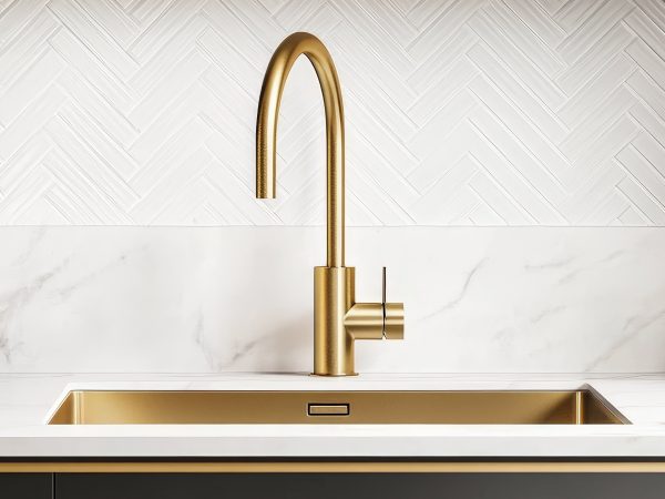Stunning close-up of a luxurious kitchen sink showcasing a gold faucet.