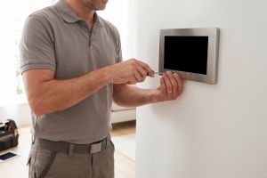 Technician Installing Smart Home Technology Control Panel on Wall