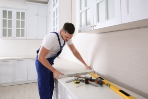Worker Installing New Countertop in Modern Open Concept Kitchen